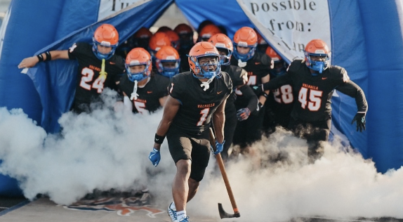 West Orange Warriors players running out of the tunnel through smoke